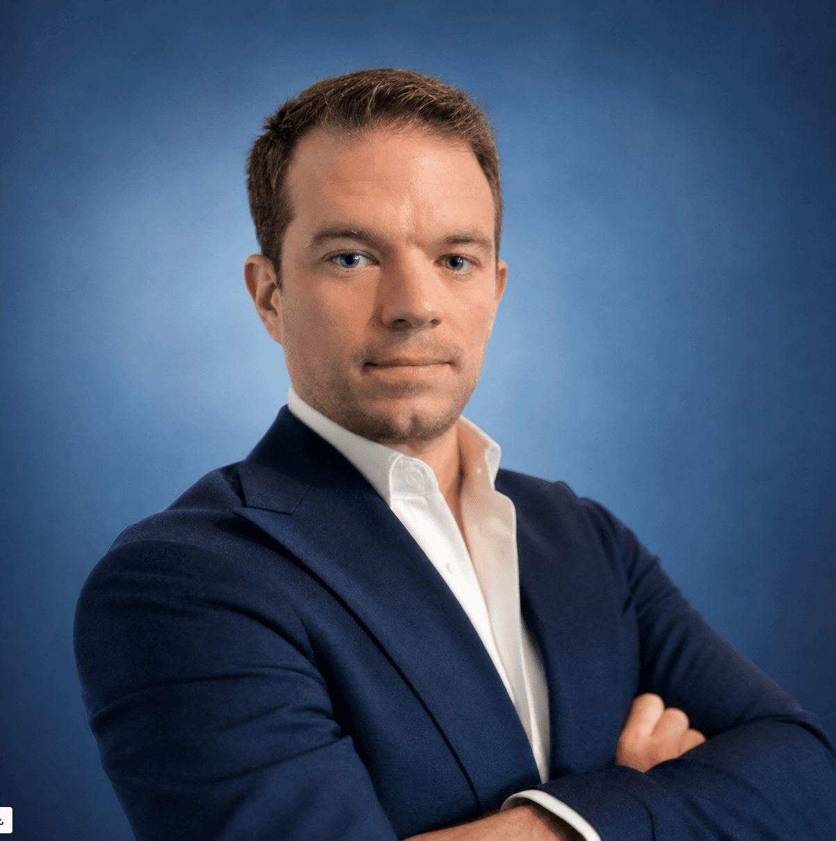 Portrait du conseiller en costume bleu marine, bras croisés.